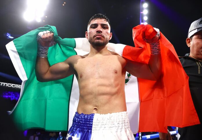 Andres Cortes poses with the flag of Mexico after his boxing bout against Alexis del Bosque