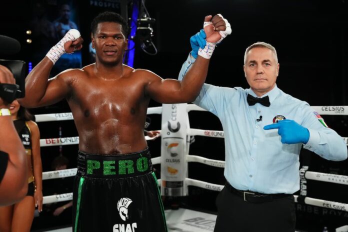 Referee Massimo Montanini raises Dainier Pero's hand in victory over Joe Jones after their boxing match
