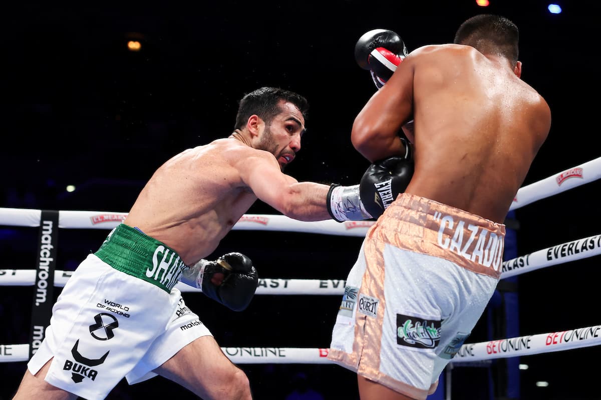 Shakhram Giyasov punches Franco Maximiliano Ocampo to the body during their boxing bout