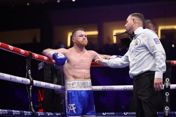 The referee gives Canelo Alvarez a warning during his boxing match against William Scull