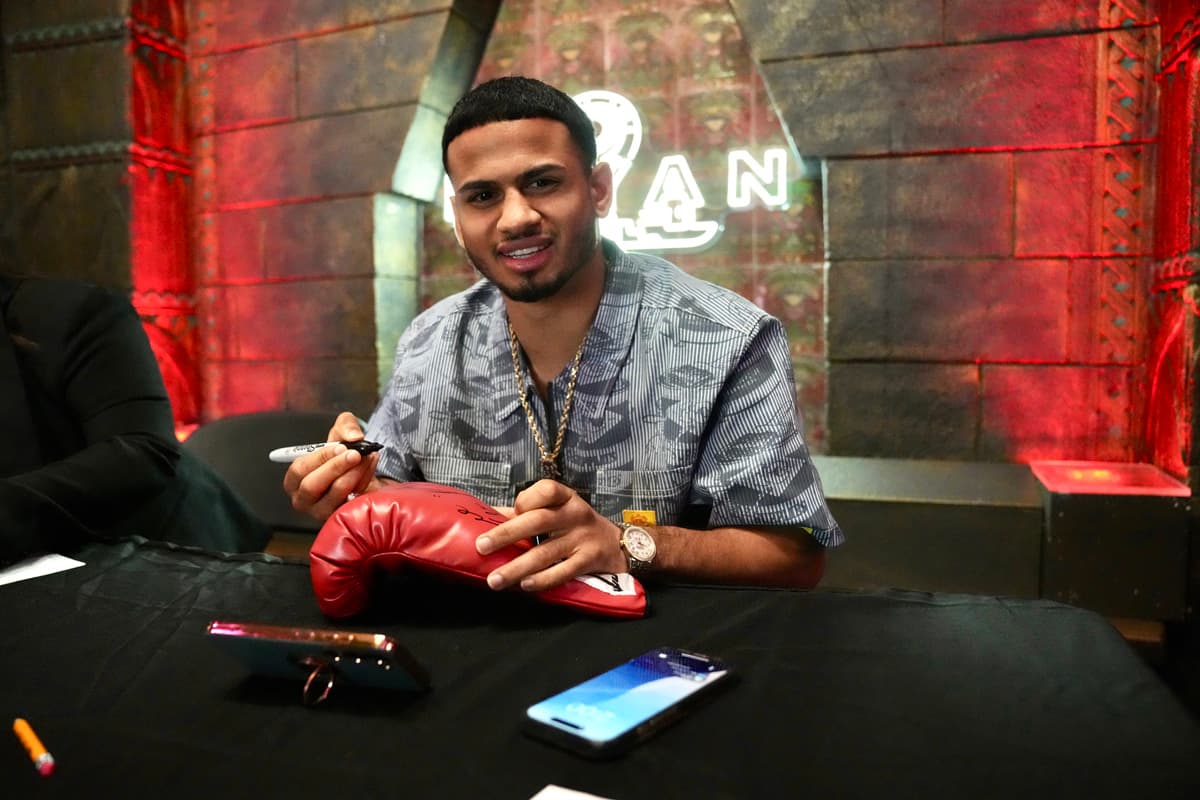 Rolando Romero signs gloves during a media roundtable in Los Angeles