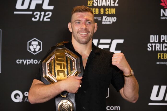 Dricus Du Plessis poses with his championship belt during the UFC 312 post-fight press conference