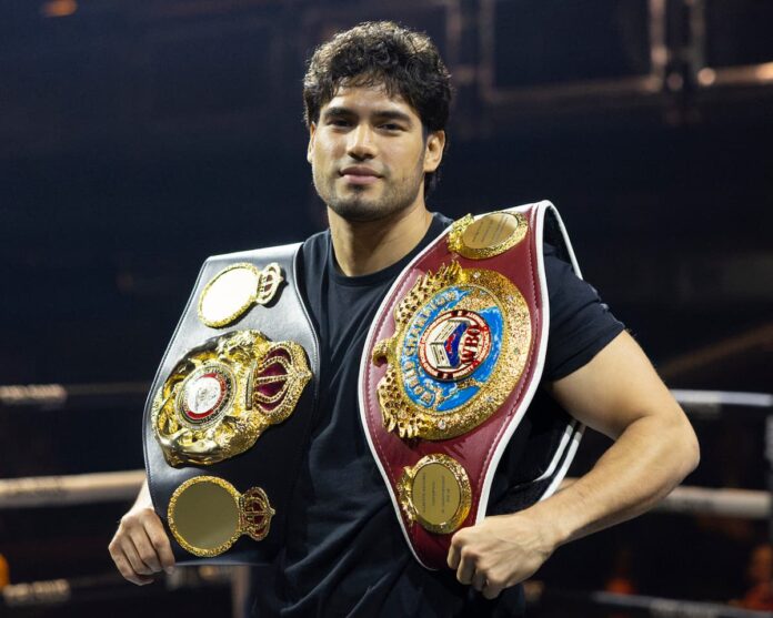 Gilberto 'Zurdo' Ramirez poses in the boxing ring with his championship belts