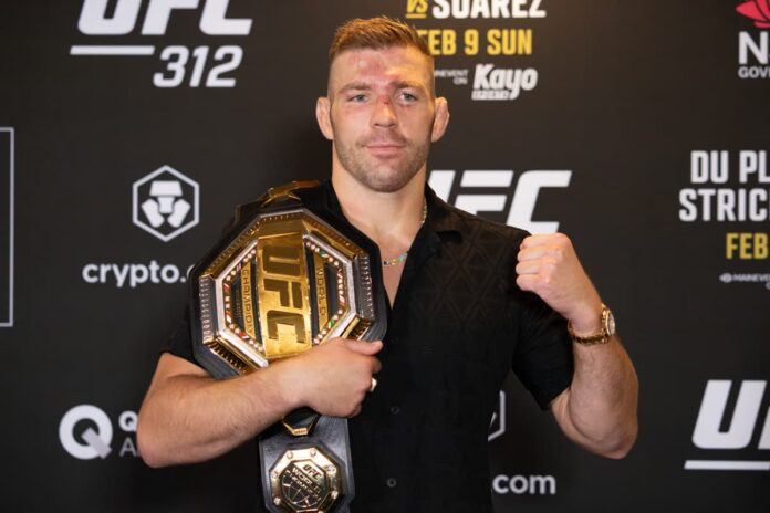 Dricus Du Plessis poses with his championship belt during the UFC 312 post-fight press conference