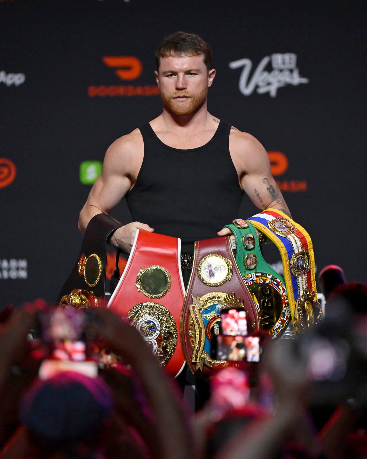 Canelo Alvarez posing with his belts