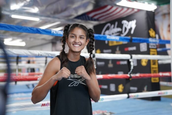 Gabriela Fundora posing in front of a boxing ring