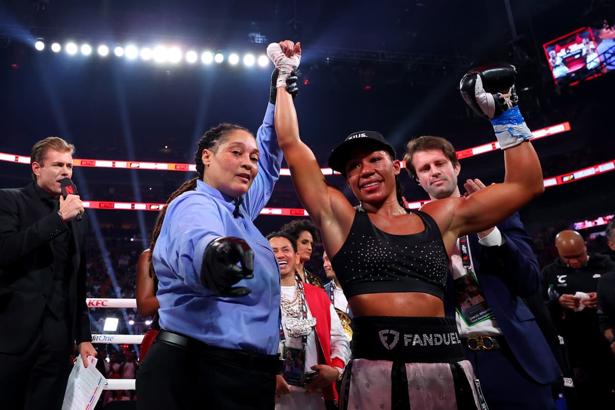 Referee Alicia Collins raises Alycia Baumgardner's hand in victory over Leila Beaudoin during their boxing bout