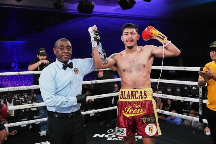 Referee Chris Young raises Daniel Blancas' hand in victory during his boxing bout