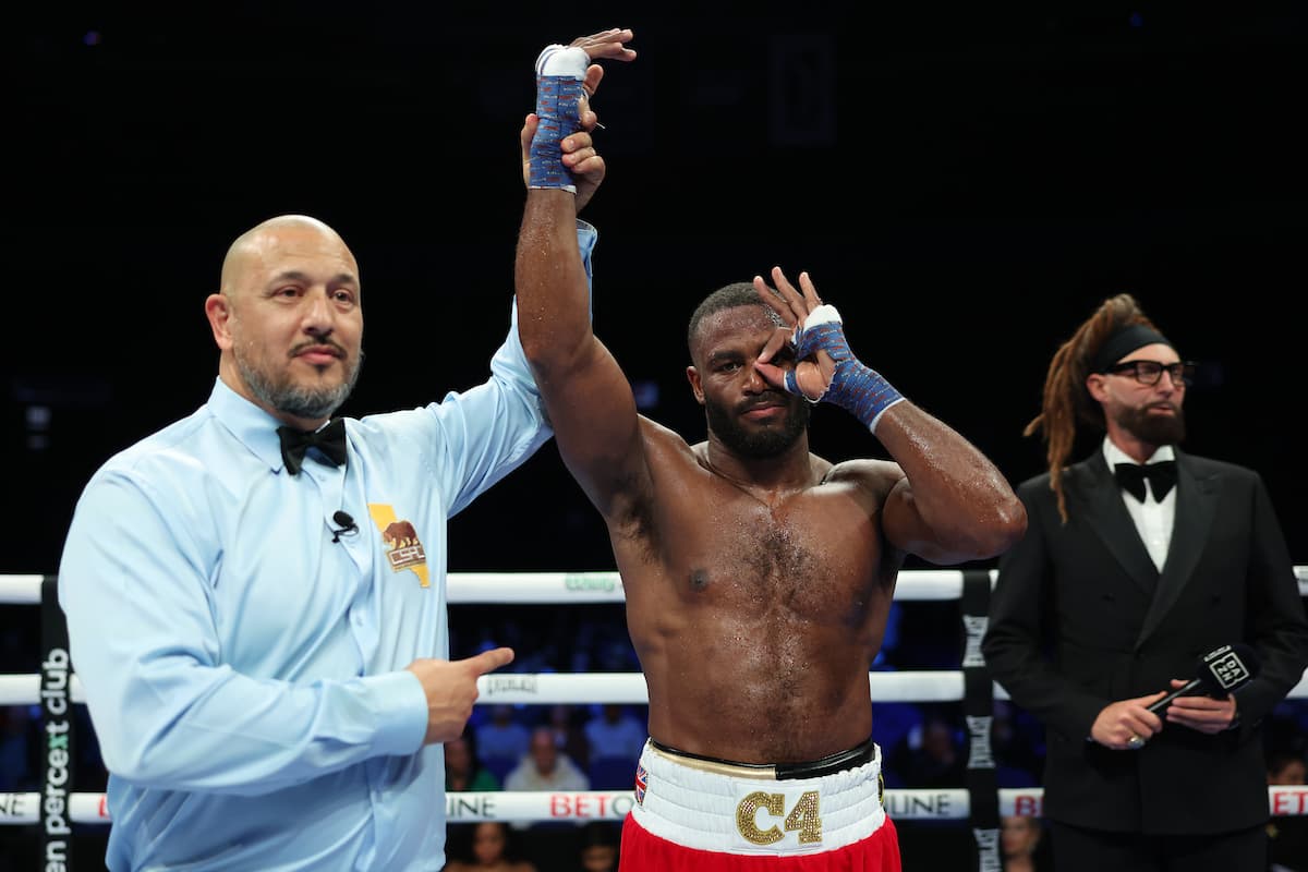Referee Michael Margado raises Cheavon Clarke's hand in victory over Anthony Hollaway