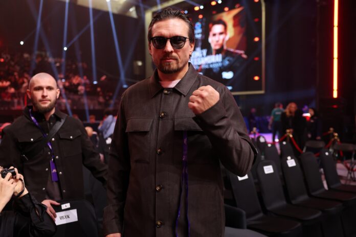 Oleksandr Usyk poses with his fist raised while attending the Inoue vs Picasso boxing event