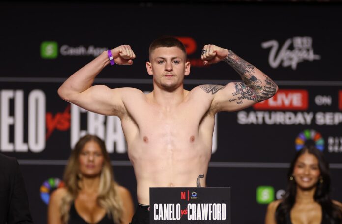 Callum Walsh posing on the scale during a weigh-in