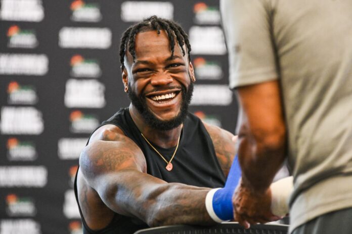 Deontay Wilder smiles while getting his hands wrapped during an open workout
