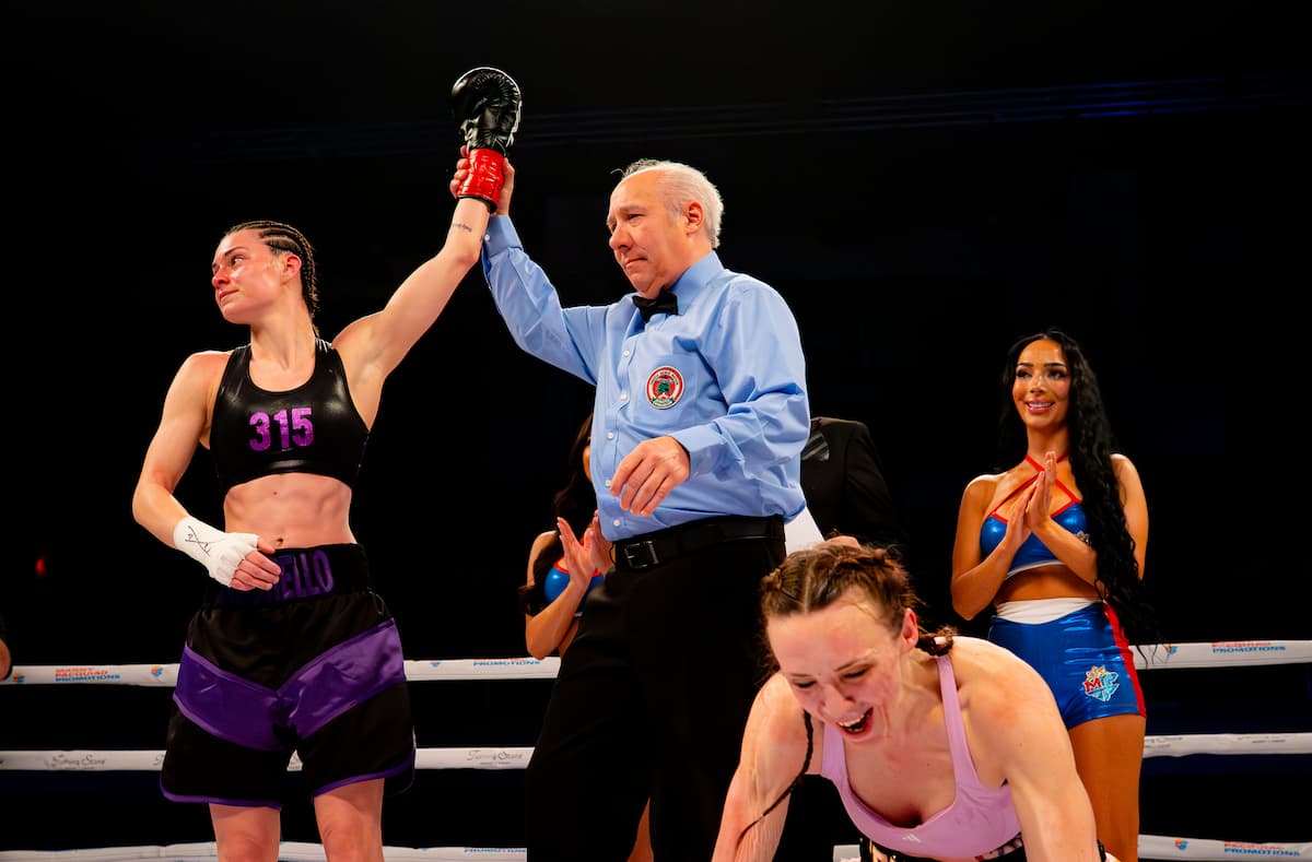 The referee raises Damiana Andrello's hand after her victory over Jessica Radtke Maltez in their boxing match