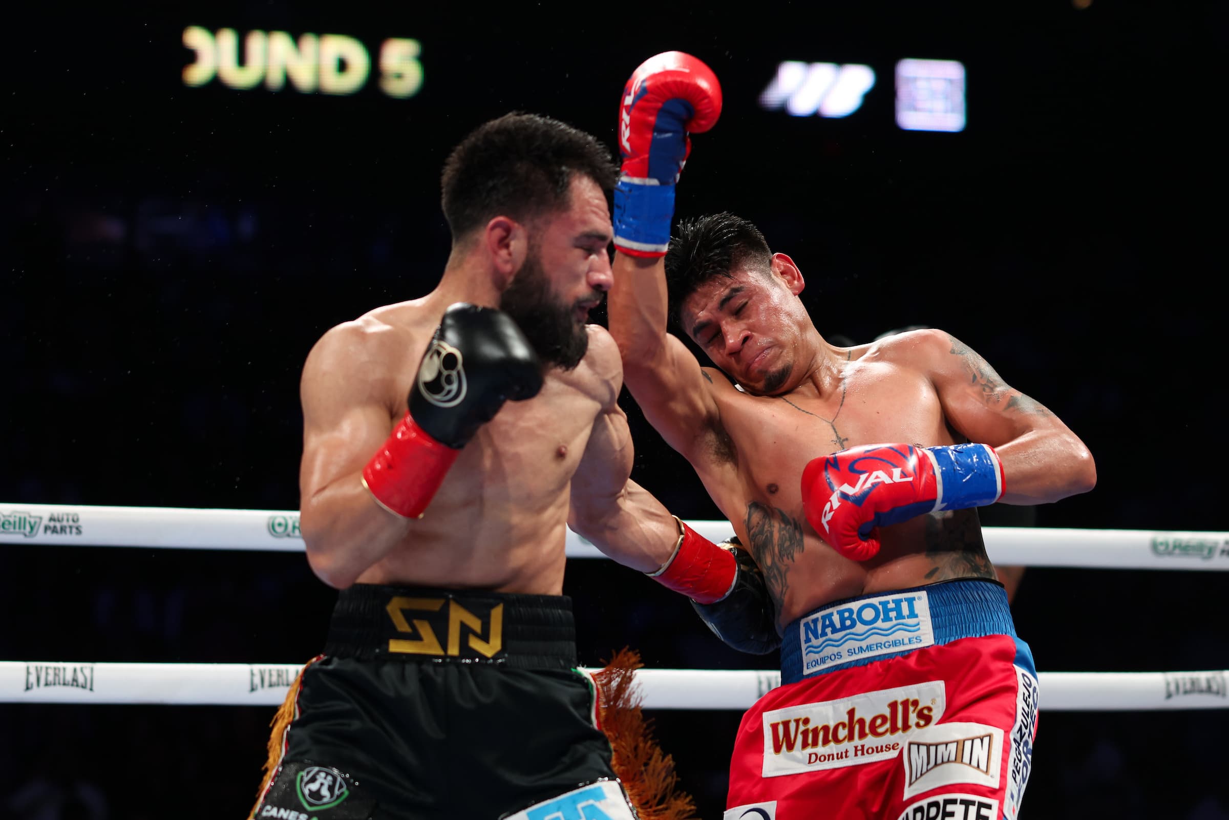 Emanuel Navarrete throws an uppercut during his bout against Eduardo Nunez