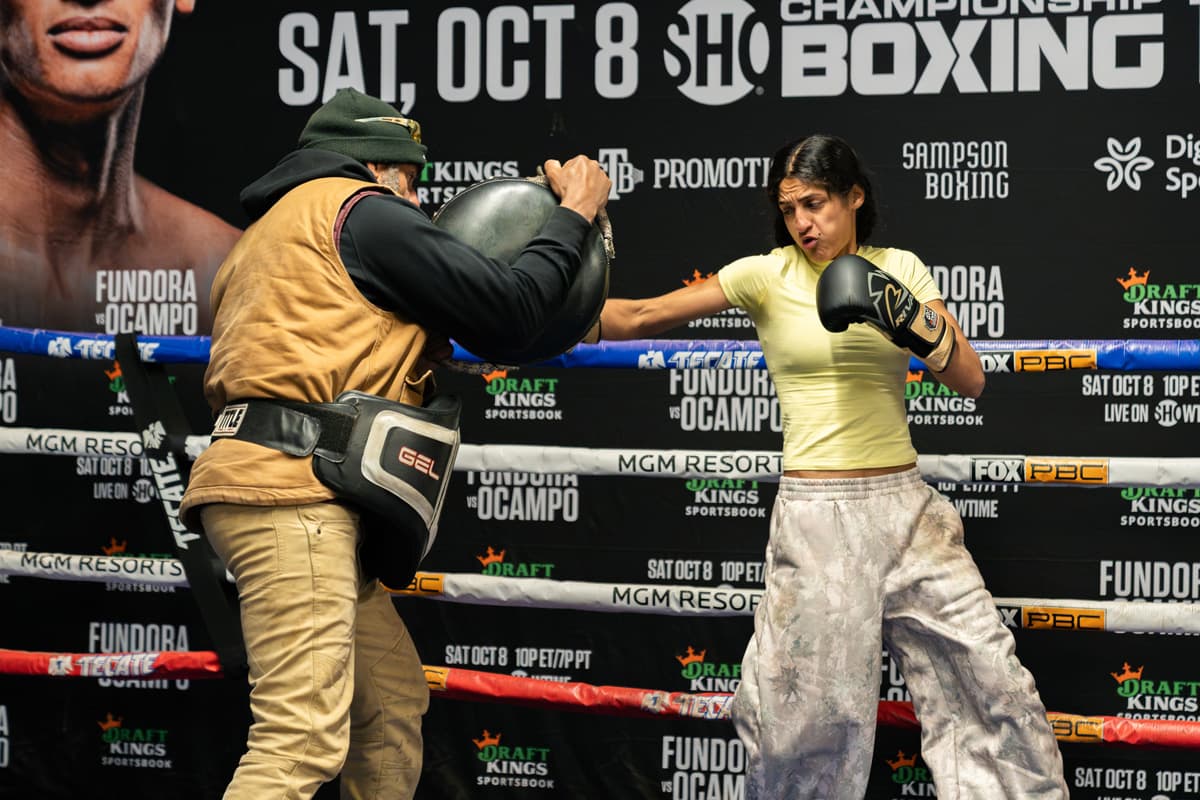 Gabriela Fundora punches while Freddy Fundora holds a pad during a boxing training session