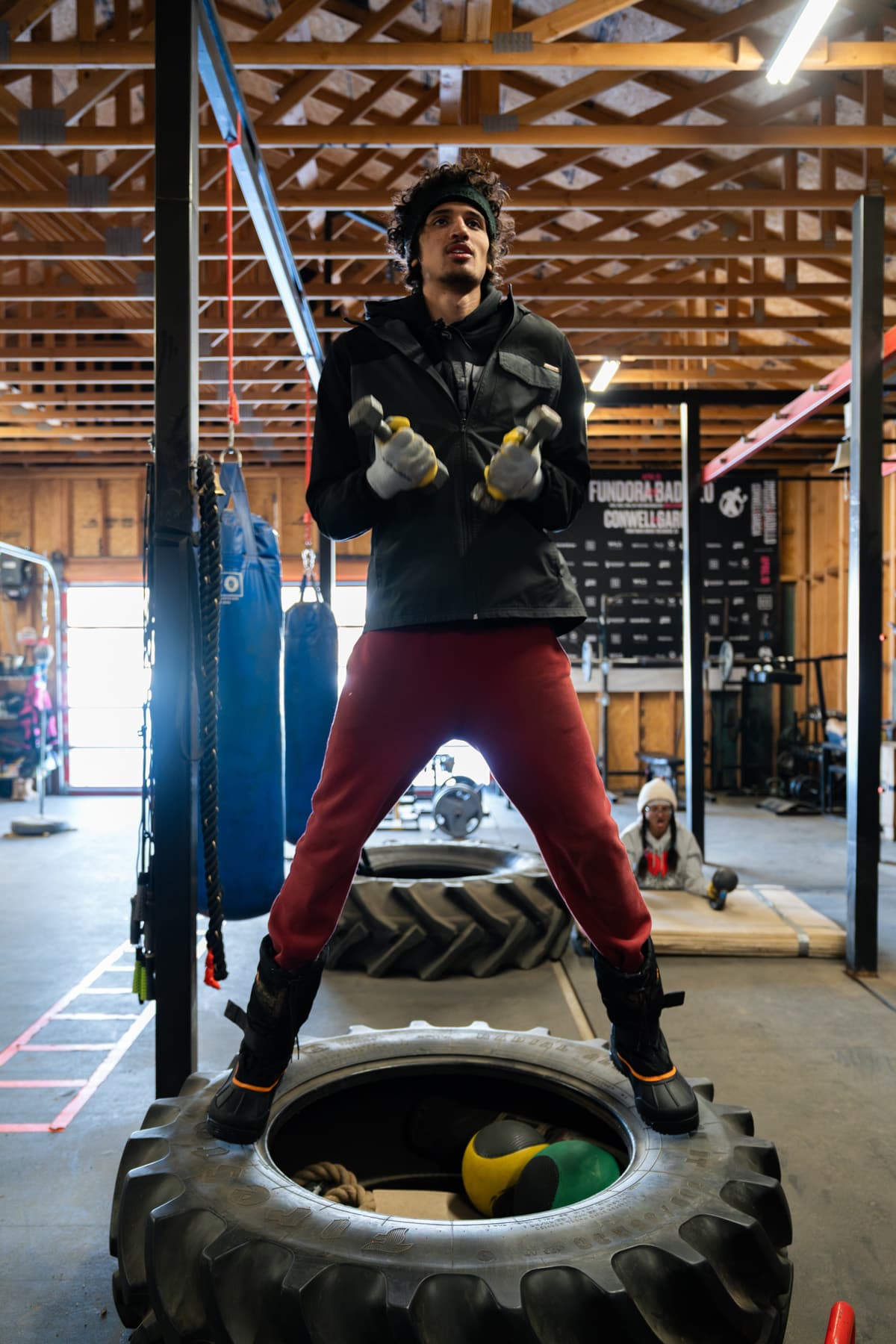 Sebastian Fundora standing on a tire while holding weights during a training session