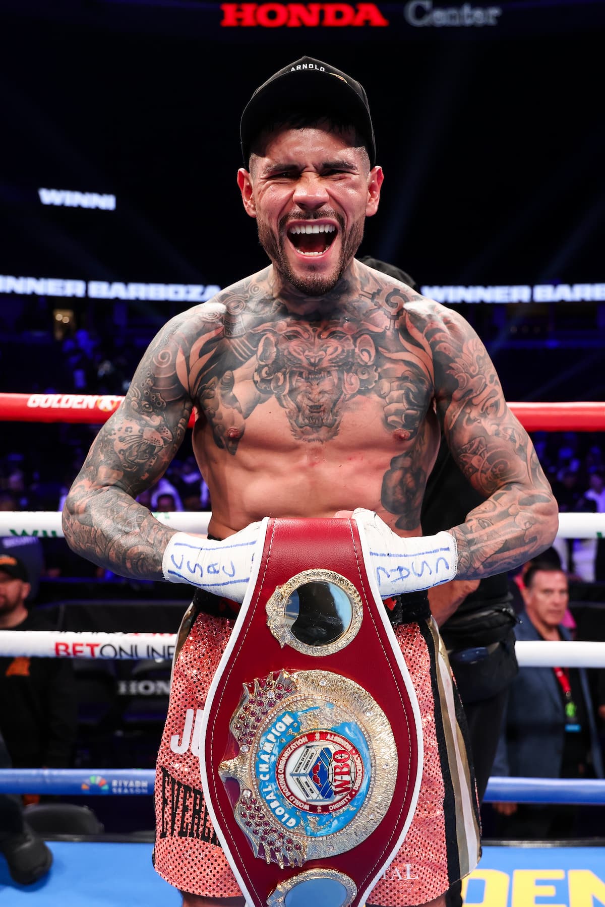 Arnold Barboza Jr posing in the ring with his WBO championship belt celebrating victory