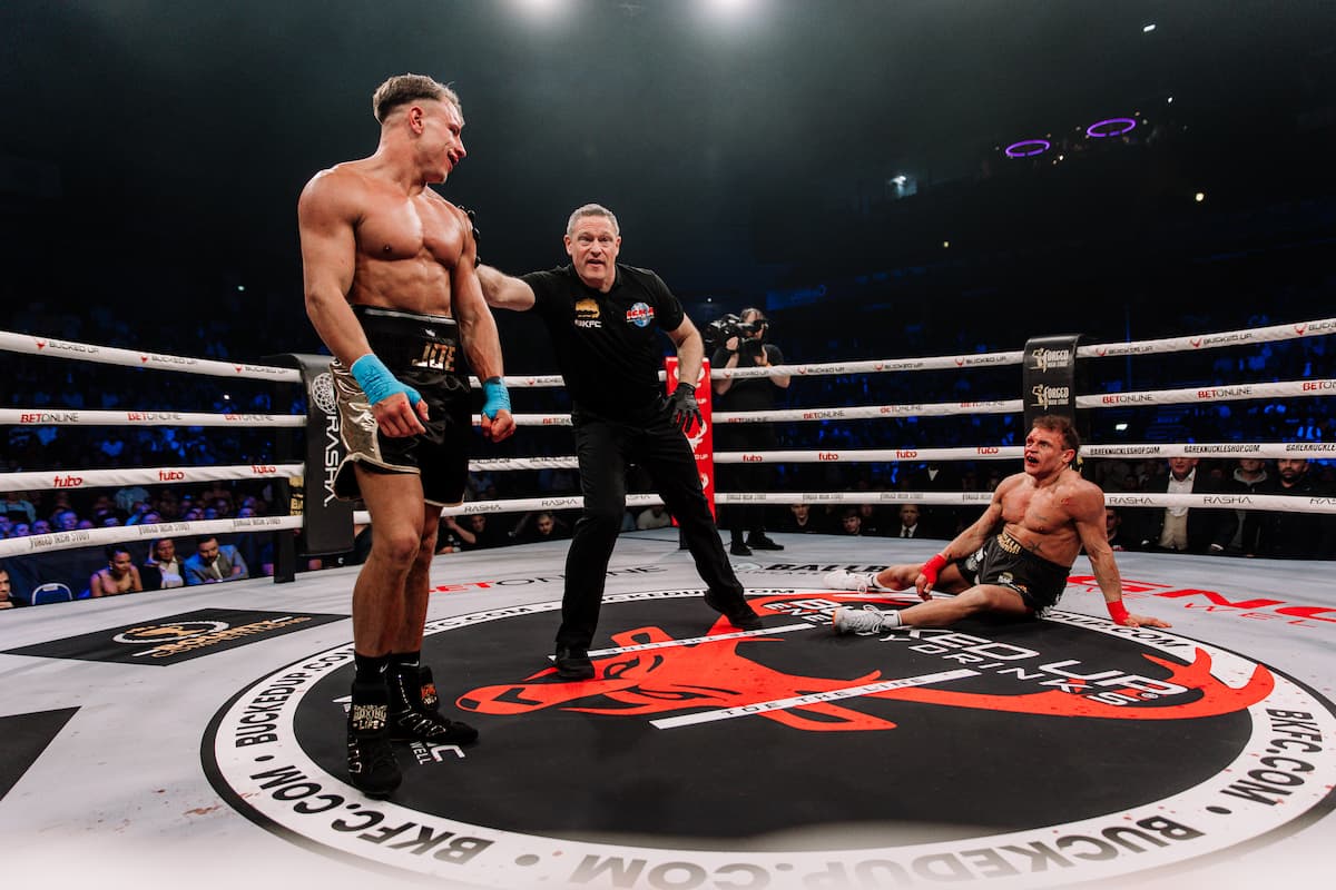 Joe Listerknocks down Danny Wall during their bout