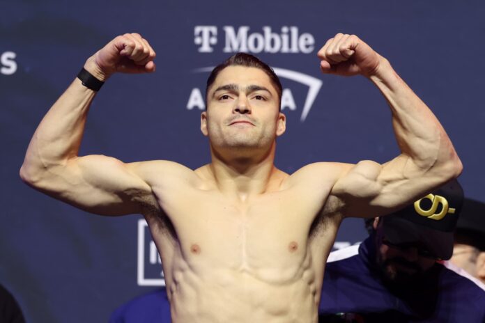 Oscar Duarte on the scales with his hands raised during the weigh-in ahead of his boxing match