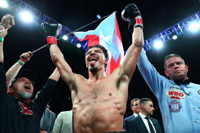 Referee raises Xander Zayas' hand in victory after a boxing match