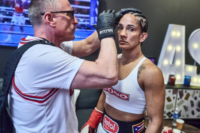 Amanda Serrano backstage, being prepared by a team member ahead of her boxing match