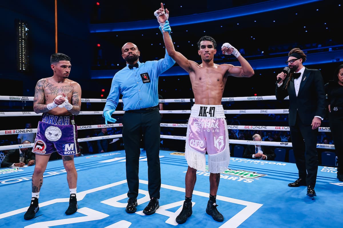 The referee raises Angel Barrientes' hand in victory