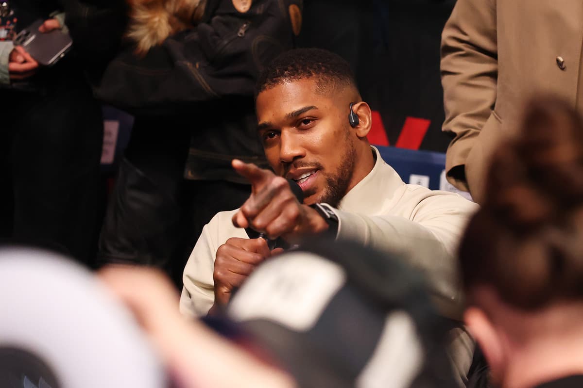 Anthony Joshua sitting in the crowd while pointing during a post-fight moment