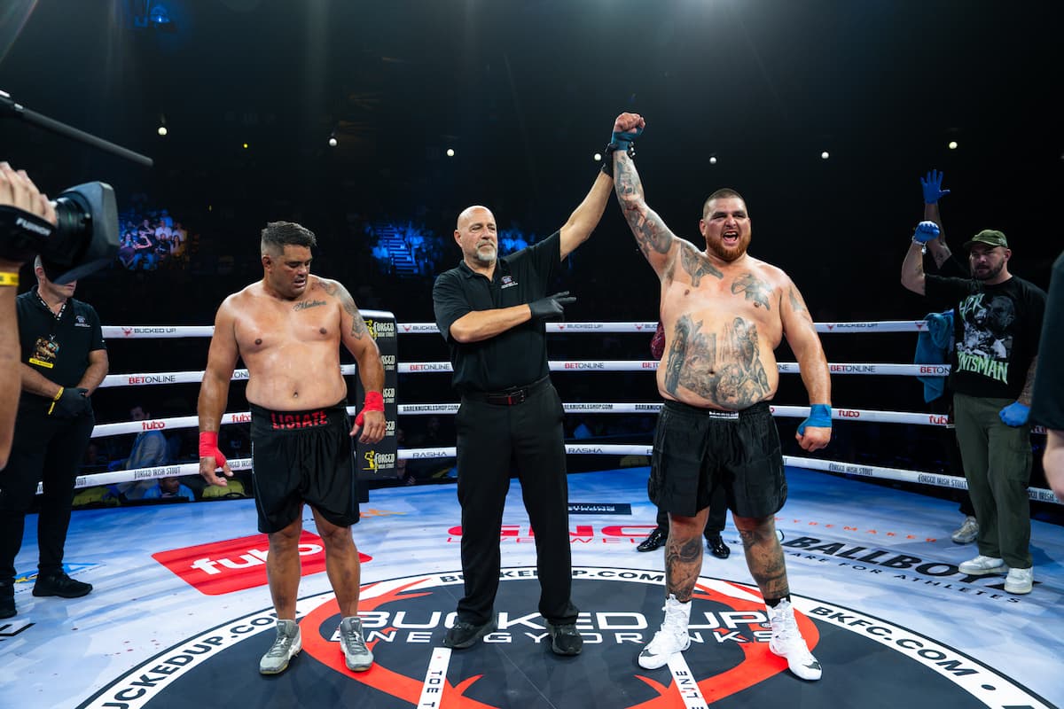 The referee raises Darcy Braine's hand in victory over Richie Fa'’aoso after their heavyweight bout