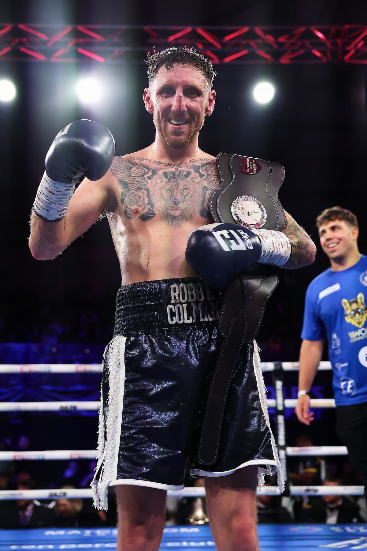 Robbie Colman in the ring holding his championship belt after defeating Josh Blenkiron in their boxing match