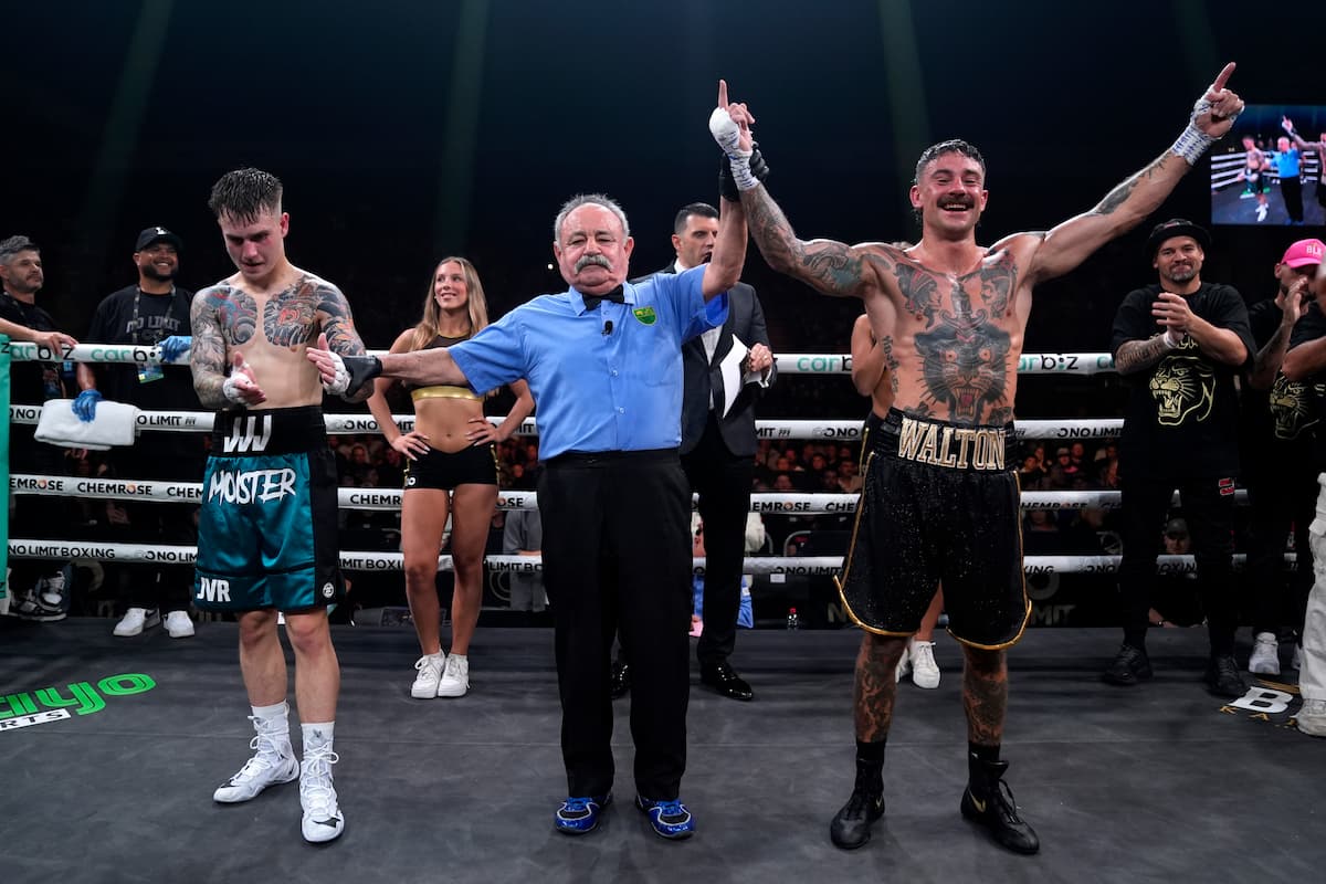 The referee raises Brent Walton's hand in victory