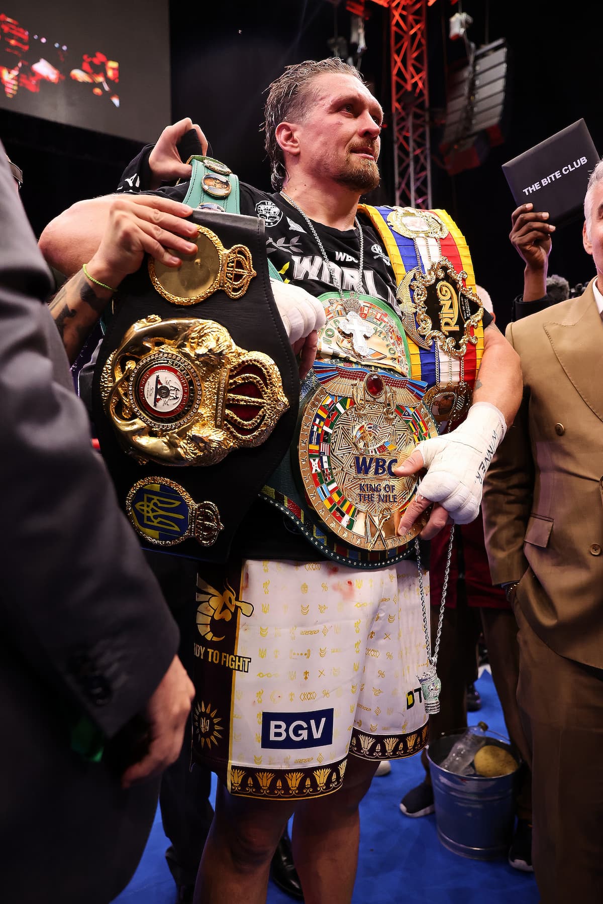 Oleksandr Usyk holding championship belts after victory
