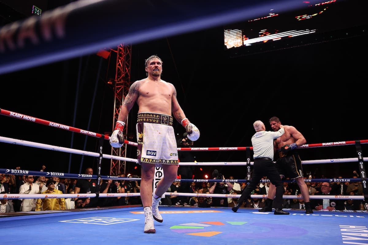 Oleksandr Usyk walking away as referee attends to Rico Verhoeven