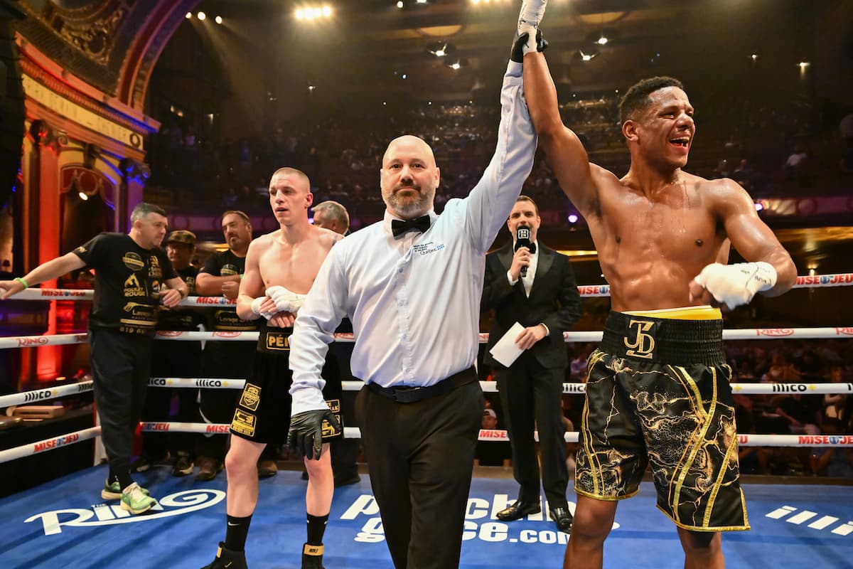 The referee raises Jordan Dzaba's hand in victory over Daylen Pepin