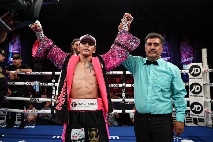 Neider Valdez has his hand raised by referee Cesar Garcia after victory