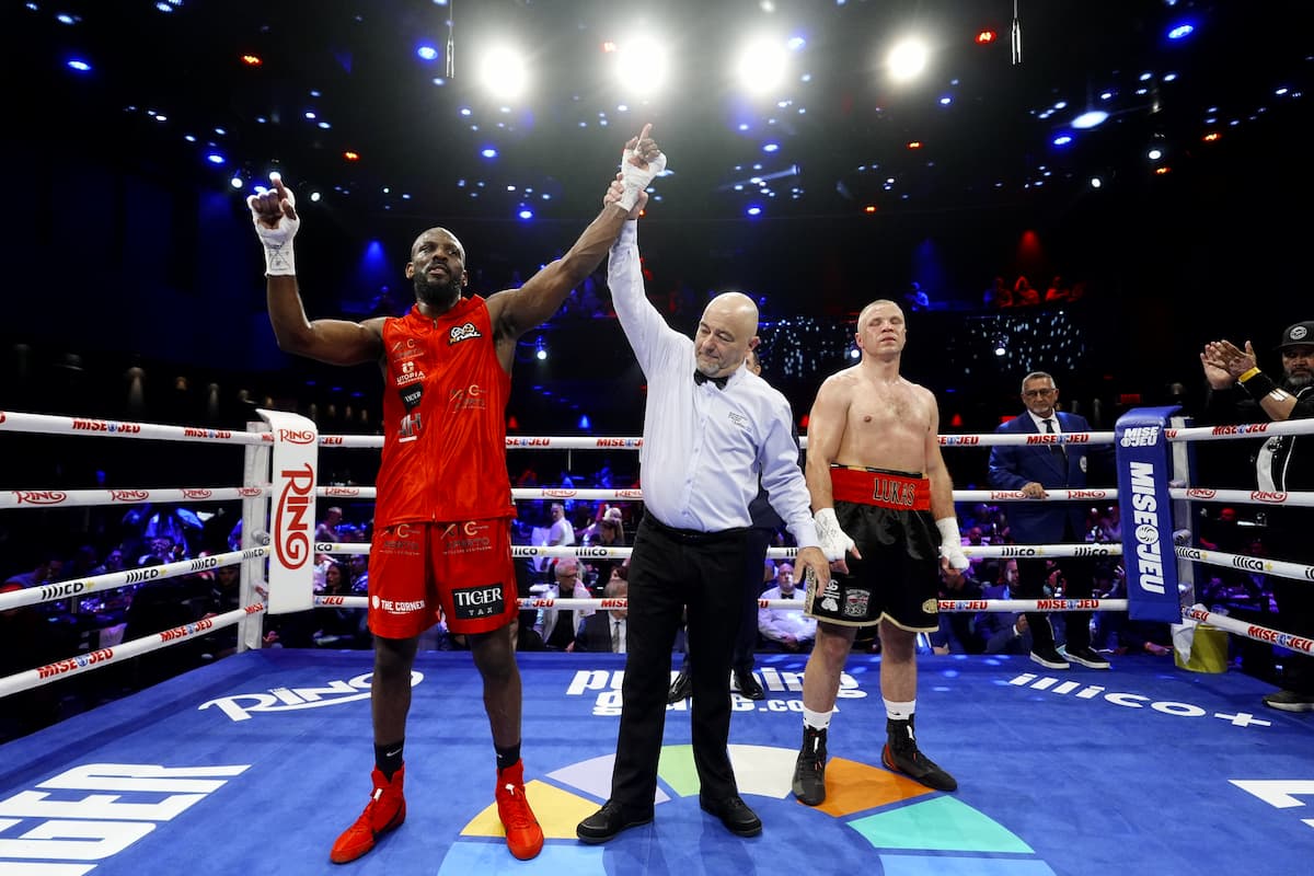 The referee raises Nickenson Denis' hand in victory over Lukasz Kucharski