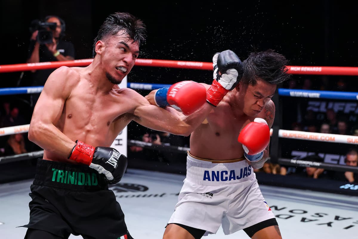 Omar Cande Trinidad throws an uppercut during his bout against Jerwin Ancajas