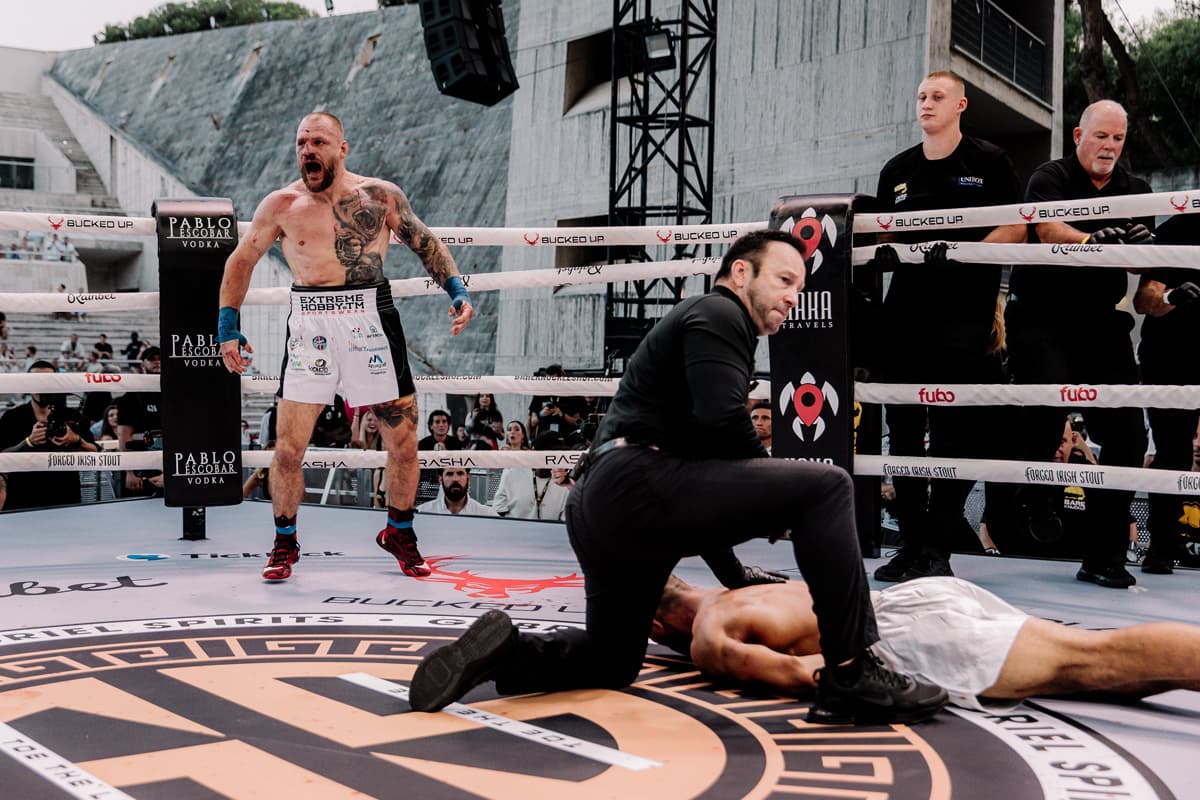 Pawel Werszynin celebrates victory as Ramy Elsayes lies on the canvas attended by the referee