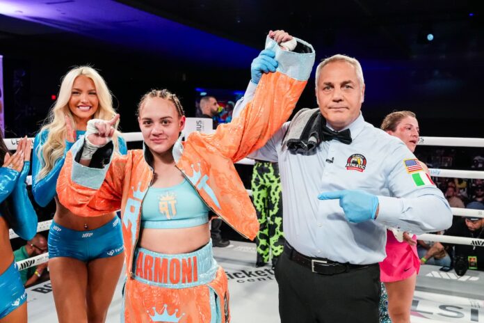 Reina Tellez has her hand raised in victory over Maria Salinas