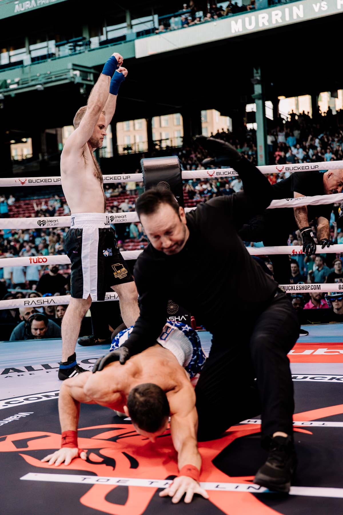James Murrin celebrates his victory as the referee attends to Chris Rooney after a knockdown