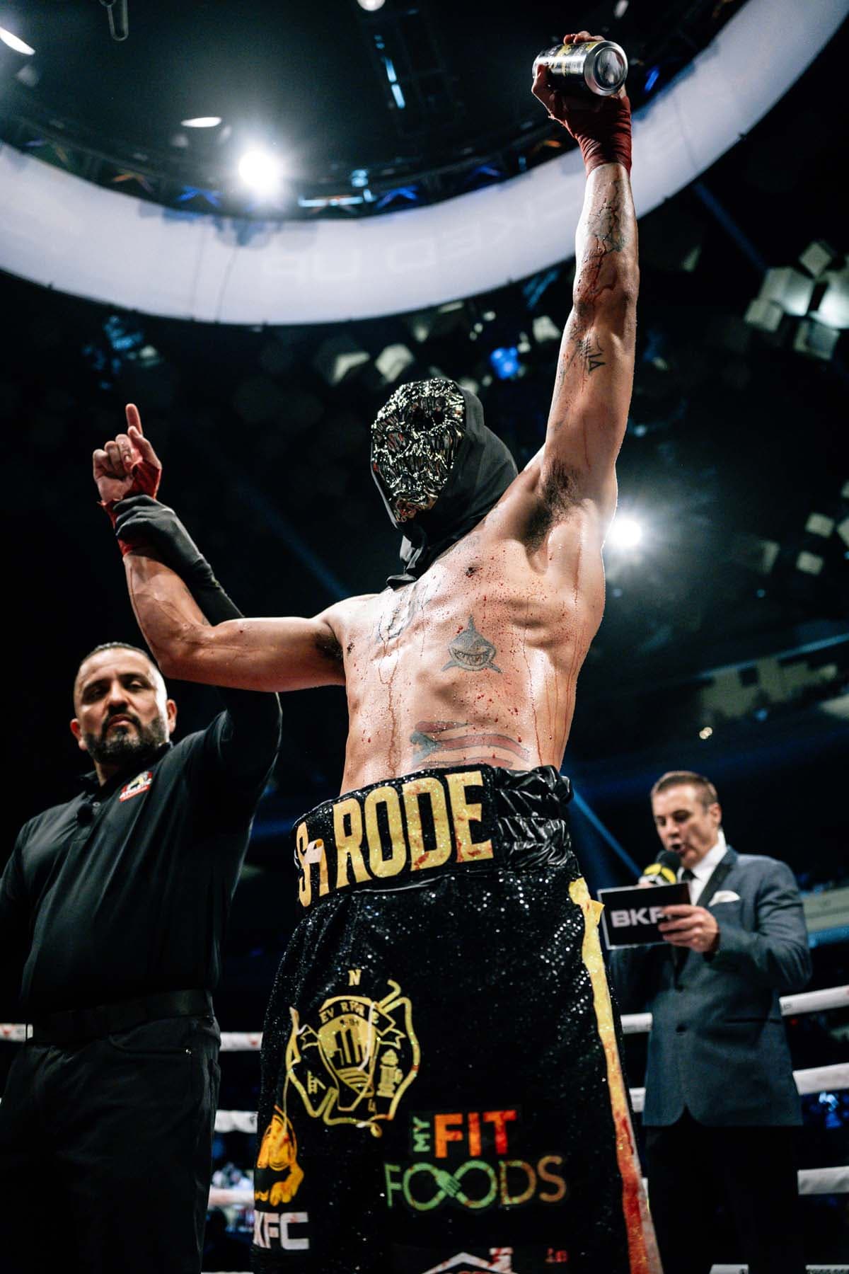 Andrew Strode has his hand raised after his victory over Gee Perez