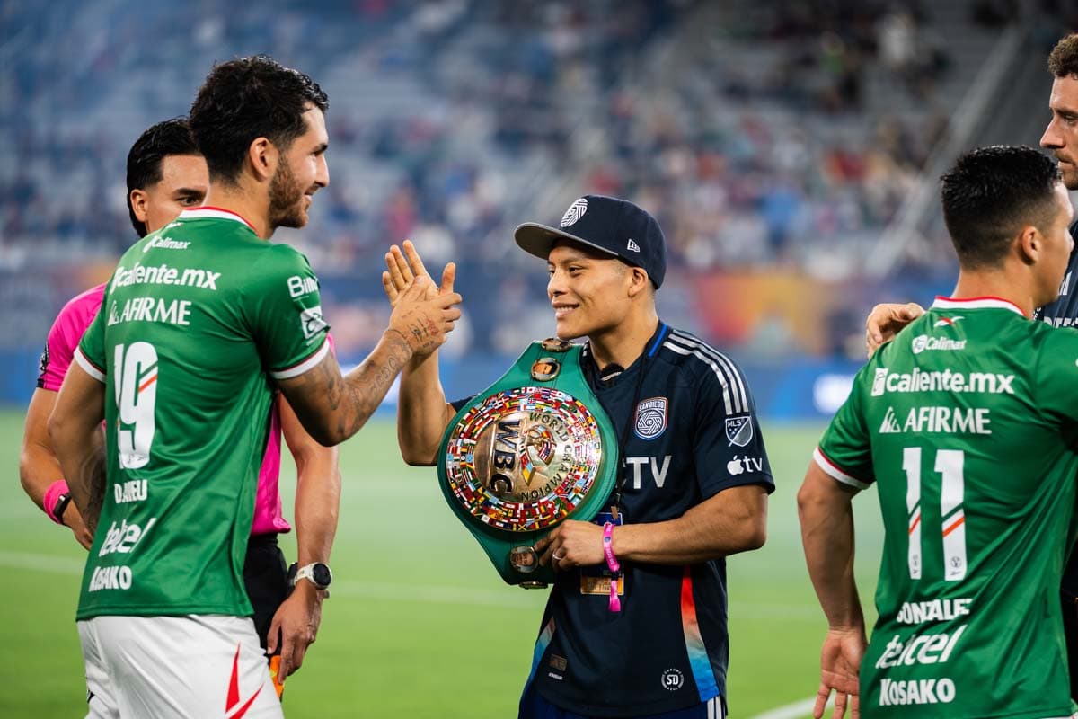Isaac Cruz high-fives a Club Tijuana member on the field
