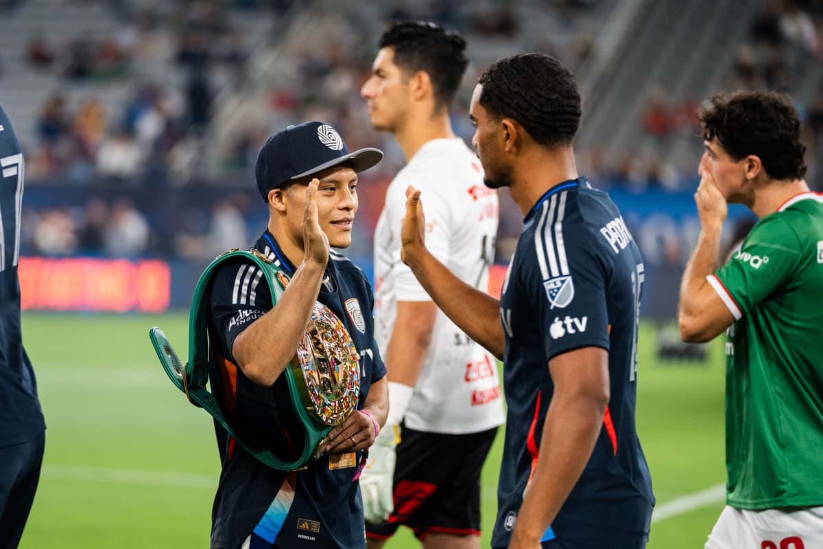 Isaac Cruz high-fives a San Diego FC member on the field at Snapdragon Stadium