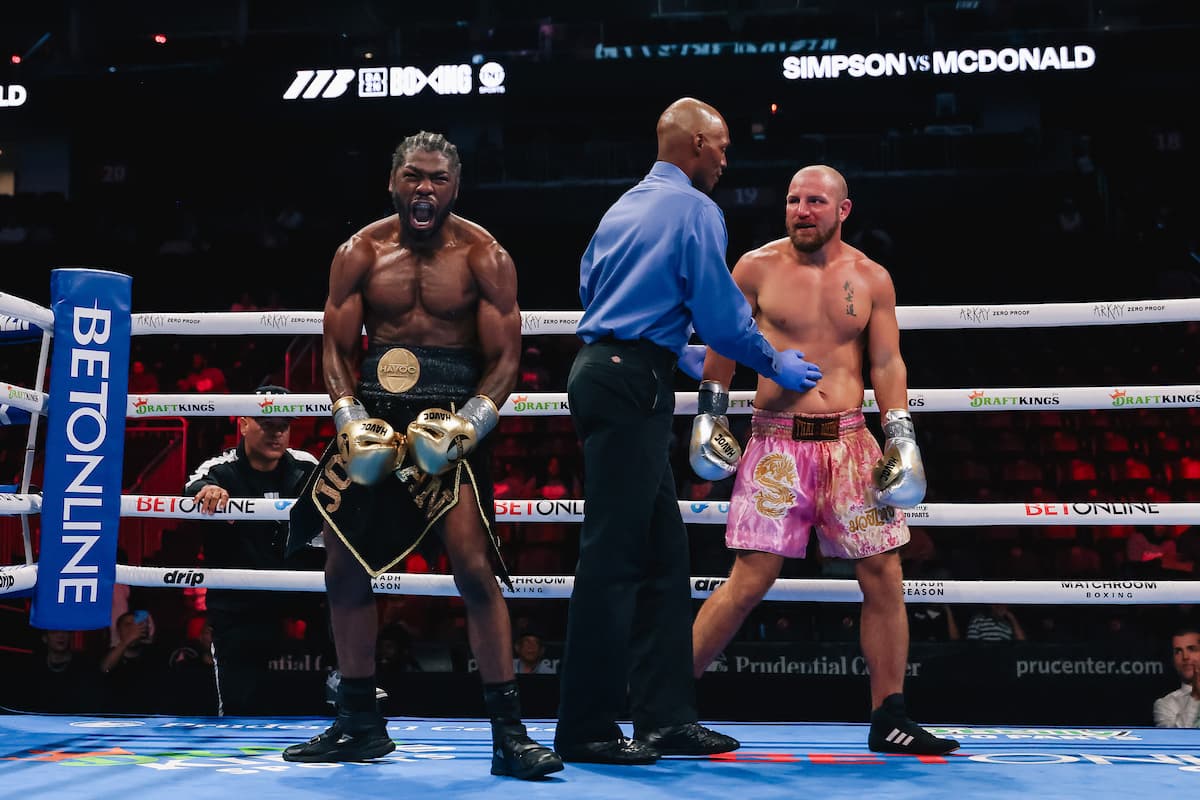 Jordan Simpson celebrates his victory as the referee attends to Michael McDonald