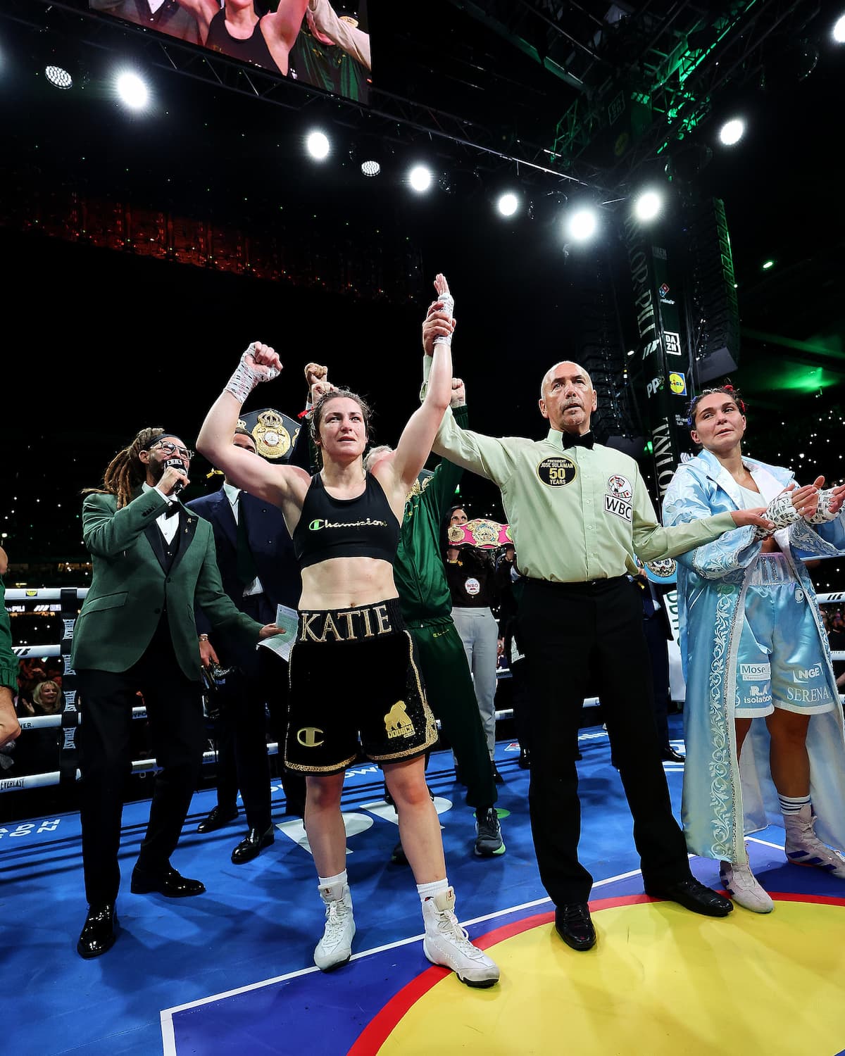 Referee David John Irving raises Katie Taylor's hand in victory over Flora Pili