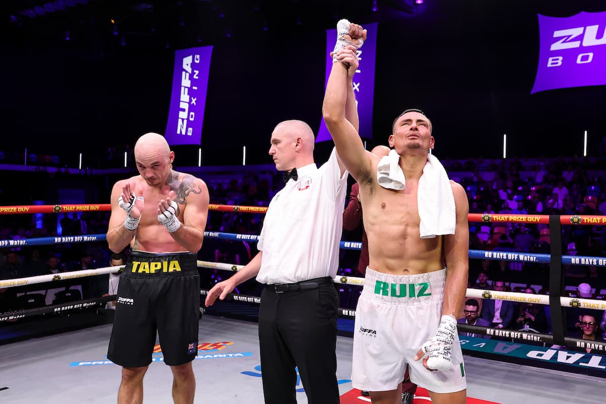 Leonardo Ruiz has his hand raised in victory after defeating Cesar Mateo Tapia