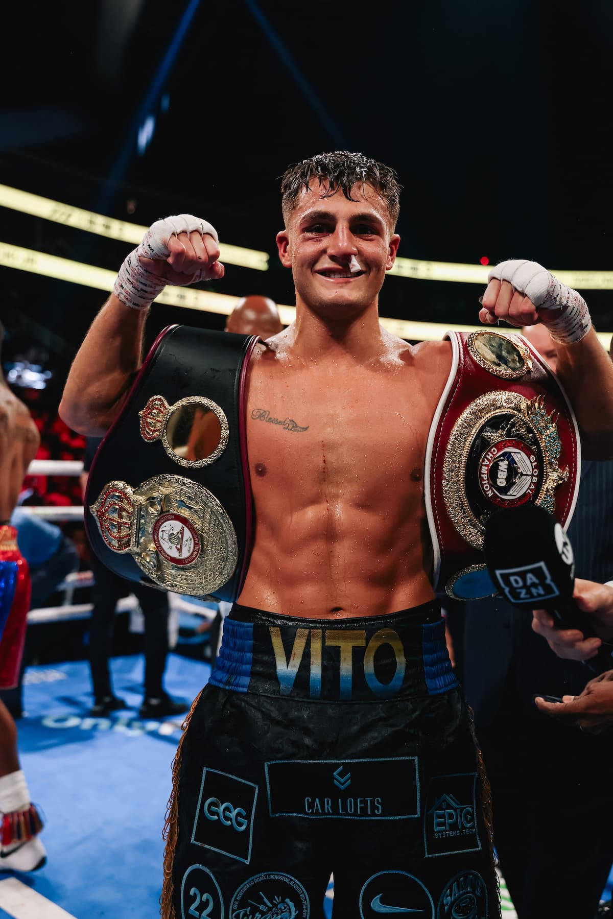 Vito Mielnicki Jr. poses with his championship belts after his victory over Austin Williams